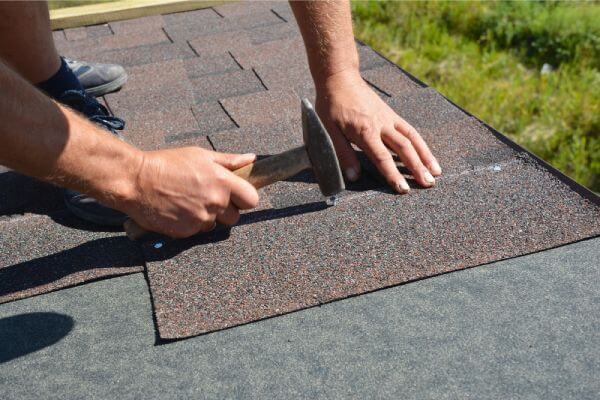asphalt-shingles-installation-roofer-contractor-hands-installing